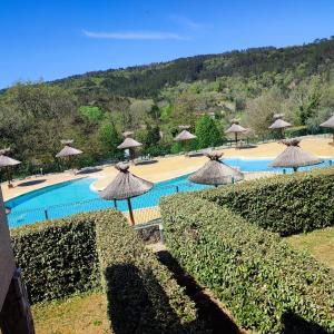 a resort with a swimming pool with umbrellas at Maison de 3 chambres avec piscine partagee jardin et wifi a Salavas in Salavas