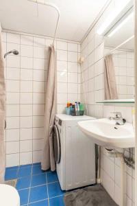 y baño con lavabo y lavadora. en Quite room in apartement en Oslo