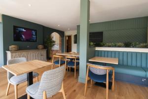 un restaurante con mesas de madera y sillas azules en Penrhos Park, en Llanrhystyd
