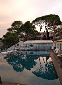 a swimming pool with a reflection in the water at Thalazur Bandol Ile Rousse - Hôtel & Spa in Bandol