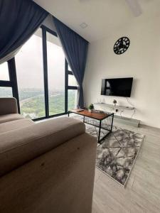 een woonkamer met een bank en een klok aan de muur bij Sky Park Cyberjaya, 2room nice view, Airport, KLIA in Cyberjaya