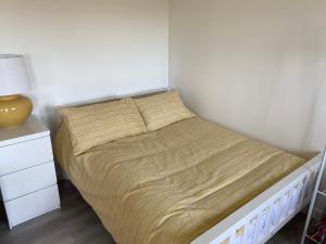 a bed in a small room with a yellow lamp at The Little Cabin in St Ives