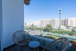 a balcony with two chairs and a view of a city at Paris-Oasis Casablanca avec piscine panoramique in Casablanca