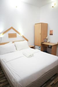 Schlafzimmer mit einem großen weißen Bett und einem Schreibtisch in der Unterkunft Golhaaviewinn in Thulusdhoo
