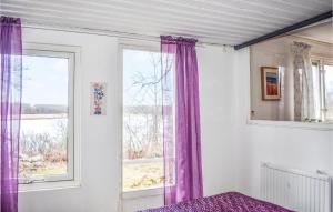 a bedroom with purple curtains and a window at Gorgeous Home In Lyckeby With House Sea View in Lyckeby