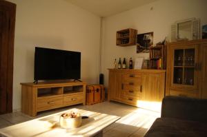 sala de estar con TV de pantalla plana en un centro de entretenimiento de madera en Ferienhaus Gerlach, en Essingen