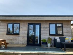 uma pequena casa com portas e janelas pretas em The Little Cabin em St Ives
