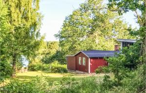 a red shed in the middle of a garden at Gorgeous Home In Lyckeby With House Sea View in Lyckeby