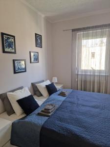 - une chambre avec un lit bleu et un canapé dans l'établissement White House Apartman Budapest, à Budapest