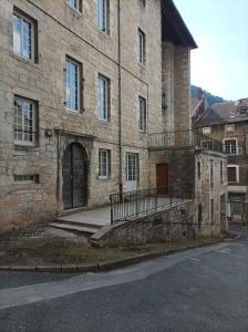 ein großes Backsteingebäude mit einer Tür und einer Treppe in der Unterkunft O'Couvent - Appartement 87 m2 - 4 chambres - A501 in Salins-les-Bains