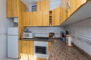 シウダー・ケサダにあるCH Villa Rubira Ciudad Quesadaのキッチン(木製キャビネット、白い冷蔵庫付)