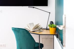 an office desk with a green chair and books at Calme & Chic vert - Proche gare et centre in Dijon