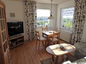 een woonkamer met een tafel en een televisie bij Ferienwohnung zum Riesenlöffel in Arnstadt