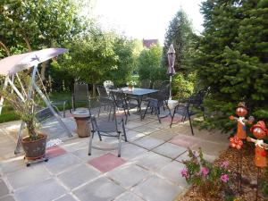 een patio met een tafel en stoelen en een parasol bij Ferienwohnung zum Riesenlöffel in Arnstadt