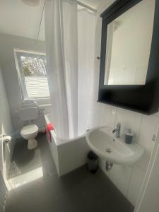 a white bathroom with a sink and a toilet at Travel Apartments in Münster