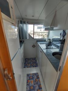 a small kitchen with white cabinets and a sink at Boat Sirio in San Miguel de Abona