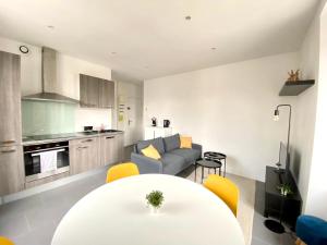 cocina y sala de estar con mesa blanca y sillas amarillas en Magnifique T2 40m2 lumineux, moderne et rénové avec fibre en Belfort