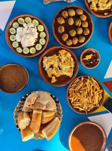 a blue table topped with plates of food and snacks at malindy KA ماليندى كا in Aswan