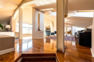 una sala de estar de planta abierta con suelo y techo de madera. en Hotel Ferrara, en Ferrara