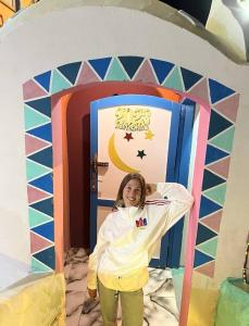 a young girl standing in a pretend play house at malindy KA ماليندى كا in Aswan
