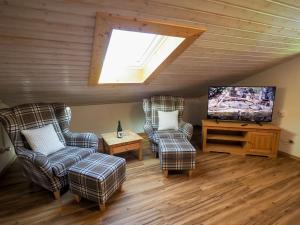 a living room with two chairs and a flat screen tv at Ferienwohnung Wiesenlehen in Bischofswiesen