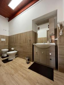 ein Badezimmer mit einem Waschbecken, einem WC und einem Spiegel in der Unterkunft Affittacamere Vicino al Porto in Porto Torres