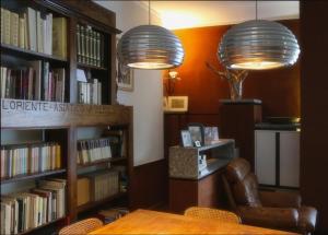 una biblioteca con dos lámparas y una silla y libros en B&B Casa Mancini en Rímini