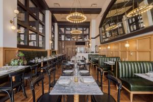 uma sala de jantar com mesas e cadeiras e um lustre em Hotel Figueroa, Unbound Collection by Hyatt em Los Angeles