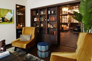 a living room with two chairs and a book shelf at Hotel Figueroa, Unbound Collection by Hyatt in Los Angeles