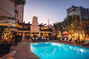 a swimming pool with chairs and a building at Hotel Figueroa, Unbound Collection by Hyatt in Los Angeles