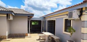 a house with a bench in front of it at Labas Travellers Guesthouse in Jozini