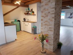 una cocina con una pared de ladrillo y un jarrón de flores en Ferienhaus Relax Ranch en Hiltpoltstein
