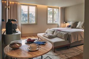 a bedroom with a bed and a table and a couch at Prim&Proper in Porto