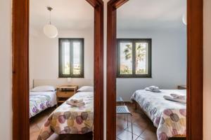 1 dormitorio con 2 camas y 2 ventanas en Residence Andrea Doria, en Marina di Ragusa