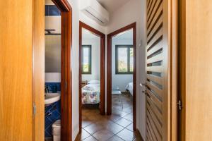 - un couloir avec une chambre dotée d'un lit et d'un miroir dans l'établissement Residence Andrea Doria, à Marina di Ragusa