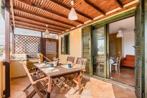 a dining room with a wooden table and chairs at Residence Andrea Doria in Marina di Ragusa