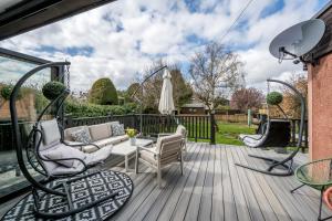 a patio with chairs and a table on a deck at Luxury 5 bedroom Victorian home with Hot Tub in Blairgowrie