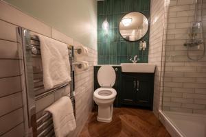 a bathroom with a toilet and a sink and a mirror at Berkshire Arms by Chef & Brewer Collection in Midgham