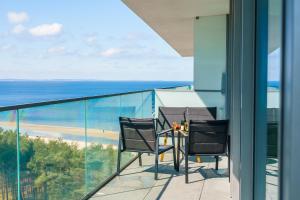 d'un balcon avec une table et des chaises donnant sur l'océan. dans l'établissement Apartament Waves - Baltic View by Renters, à Międzyzdroje