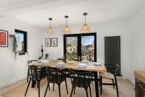 a dining room with a wooden table and black chairs at Luxury 5 bedroom Victorian home with Hot Tub in Blairgowrie