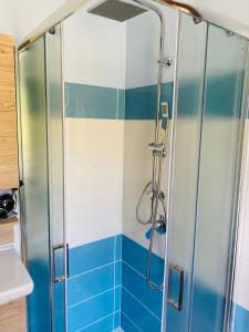 y baño con ducha y azulejos azules y blancos. en B&B Girasole, en Torraca