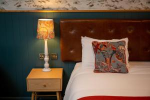 a bedroom with a bed with a lamp on a night stand at Berkshire Arms by Chef & Brewer Collection in Midgham