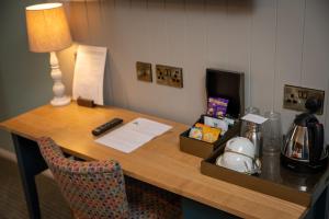 a desk in a hotel room with a lamp and a chair at Berkshire Arms by Chef & Brewer Collection in Midgham