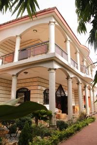 un gran edificio con columnas y balcón en Villa Mia en Abiyán