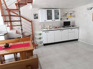 焦維納佐的住宿－Casa Vacanza Raggio di sole，厨房配有白色橱柜和螺旋楼梯
