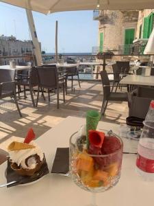 a table with a bowl of fruit and a drink at Casa Vacanza Raggio di sole in Giovinazzo