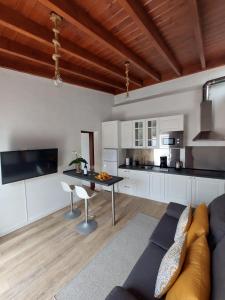 una cucina e un soggiorno con un divano e un tavolo di Casita Los Celajes a La Guancha