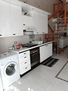 eine Küche mit einer Waschmaschine und einer Waschmaschine in der Unterkunft Casa Vacanza Raggio di sole in Giovinazzo