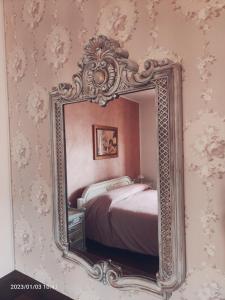 a mirror hanging on a wall in a bedroom at B&B Villa Lilla in San Benedetto del Tronto