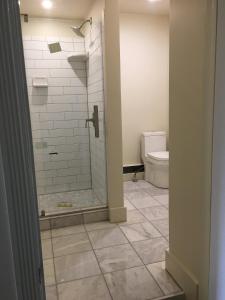 a bathroom with a shower and a toilet at Morgan State House Inn in Albany